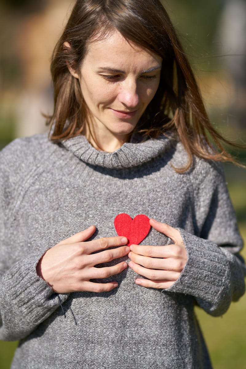 Woman holding a paper hear to her chest, symbolic of good heart health